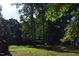 Expansive backyard with mature trees creating a private, serene setting ideal for relaxation and outdoor activities at 515 Wildwood Dr, Durham, NC 27712