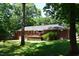 Spacious backyard featuring a wooden deck perfect for outdoor dining and entertaining, surrounded by mature trees at 515 Wildwood Dr, Durham, NC 27712