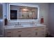 Modern bathroom featuring double sinks, a vanity with ample storage, and a large, illuminated mirror at 515 Wildwood Dr, Durham, NC 27712
