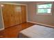 Bedroom featuring wood floors, a window and large closet for storage at 515 Wildwood Dr, Durham, NC 27712