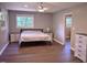 Bright bedroom with wood-look flooring, neutral walls, a ceiling fan, and ample natural light from the windows at 515 Wildwood Dr, Durham, NC 27712