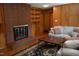 Living room with wood paneling, fireplace, built-ins and large windows at 515 Wildwood Dr, Durham, NC 27712