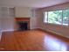 Bright living room with hardwood floors, fireplace, and large window at 515 Wildwood Dr, Durham, NC 27712