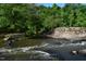 Scenic view of the Eno River with rock formations and lush green trees at 515 Wildwood Dr, Durham, NC 27712