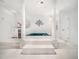 Bright bathroom with a raised jacuzzi tub, tile floor, and classic white columns at 5200 Pulley Town Rd, Zebulon, NC 27597