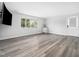 Living space with stylish floors, window with blinds, television and adjacent side cabinet at 5200 Pulley Town Rd, Zebulon, NC 27597