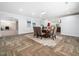 Bright dining space featuring wood-look floors, a rustic wood table, neutral chairs, and recessed lighting at 5200 Pulley Town Rd, Zebulon, NC 27597