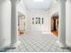 Grand tiled foyer with decorative columns and elegant front door, creating a welcoming and luxurious entrance at 5200 Pulley Town Rd, Zebulon, NC 27597