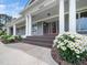 Charming home entrance with classic columns, a double door, and a beautiful flower bed at 5200 Pulley Town Rd, Zebulon, NC 27597