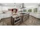 High-end kitchen boasting white cabinets, stainless steel appliances, granite countertops, an island, and a professional-grade range at 5200 Pulley Town Rd, Zebulon, NC 27597