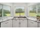 Kitchen sink area boasts granite countertops and ample natural light from three windows overlooking backyard at 5200 Pulley Town Rd, Zebulon, NC 27597