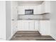 Well-lit kitchenette featuring white cabinets, gray countertop, and stainless steel microwave at 5200 Pulley Town Rd, Zebulon, NC 27597