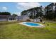 In-ground pool and backyard view with wooden fence, storage shed, mature trees and landscaping at 5200 Pulley Town Rd, Zebulon, NC 27597