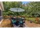 Back deck with table, six cushioned chairs and patio umbrella at 5805 Bayberry Ln, Raleigh, NC 27612