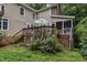 View of a backyard with a wooden deck, patio seating, and lush landscaping at 5805 Bayberry Ln, Raleigh, NC 27612