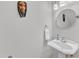 Small, minimalist bathroom with pedestal sink, decorative wall art and modern lighting at 5805 Bayberry Ln, Raleigh, NC 27612