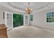 Primary bedroom with private balcony, trey ceiling, and a decorative chandelier at 5805 Bayberry Ln, Raleigh, NC 27612