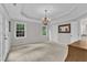 Bright primary bedroom with bright windows, neutral paint, and a decorative chandelier at 5805 Bayberry Ln, Raleigh, NC 27612