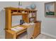 View of a wood desk with shelves, books, and lamp along with chair at 5805 Bayberry Ln, Raleigh, NC 27612