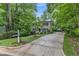 Beautiful two-story home with a long driveway surrounded by lush greenery and mature trees at 5805 Bayberry Ln, Raleigh, NC 27612