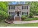 Charming two-story home with wood siding, black shutters, manicured lawn, and an American flag at 5805 Bayberry Ln, Raleigh, NC 27612