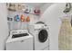 Well-organized laundry area with washer, dryer, ironing board and shelving at 5805 Bayberry Ln, Raleigh, NC 27612