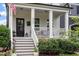 Inviting front porch with steps, railings, black door and lush landscaping at 586 Great Ridge Pkwy, Chapel Hill, NC 27517