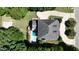 Aerial view of a property with a pool and lush landscaping, surrounded by tall trees and a winding driveway at 6217 Battleford Dr, Raleigh, NC 27612