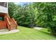 Spacious backyard with mature trees, a basketball court, and a staircase leading to the back of the house at 6217 Battleford Dr, Raleigh, NC 27612