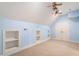 Carpeted bedroom with light blue walls, custom shelving, and a vaulted ceiling with two ceiling fans at 6217 Battleford Dr, Raleigh, NC 27612