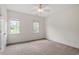 A basic bedroom with carpet, two windows, white trim, and a ceiling fan is ready for personal touches at 6217 Battleford Dr, Raleigh, NC 27612