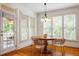 Cozy dining area with wood floors, a round table, and natural light from many windows at 6217 Battleford Dr, Raleigh, NC 27612