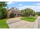 Stately brick home with a well-manicured lawn, mature trees, and an in-ground pool at 6217 Battleford Dr, Raleigh, NC 27612