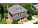 Traditional brick home featuring a covered porch, symmetrical windows, and mature trees, exuding timeless elegance at 6217 Battleford Dr, Raleigh, NC 27612