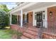 Charming brick front porch with decorative columns, black railings, and a classic front door at 6217 Battleford Dr, Raleigh, NC 27612