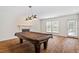Large game room featuring hardwood floors, a fireplace, and a pool table with plenty of natural light at 6217 Battleford Dr, Raleigh, NC 27612