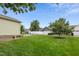 Lush green backyard with a white fence, detached garage, and landscaped trees at 6444 Kit Creek Rd, Morrisville, NC 27560