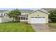Exterior home featuring garage, small patio, and vibrant green grass with an overcast sky at 6444 Kit Creek Rd, Morrisville, NC 27560