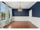 This dining room features hardwood floors, large window with patterned curtains, and modern chandelier at 6444 Kit Creek Rd, Morrisville, NC 27560
