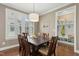 Elegant dining room featuring wood floors, a dark wood table, and bright natural light from large windows at 6444 Kit Creek Rd, Morrisville, NC 27560