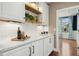 Close-up of counter with white subway tiles, wooden shelving, and view into dining room at 6444 Kit Creek Rd, Morrisville, NC 27560