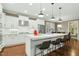 Spacious white kitchen features a large island with seating, stainless steel appliances, and hardwood floors at 6444 Kit Creek Rd, Morrisville, NC 27560