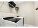 Well-lit laundry room with shelving above modern washer and dryer for organized storage at 6444 Kit Creek Rd, Morrisville, NC 27560