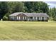 Expansive lawn surrounds this brick house with white shutters, offering curb appeal at 65 Opie Frazier Rd, Henderson, NC 27537