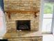 Stone fireplace with a wooden mantel and hearth, providing a cozy focal point at 65 Opie Frazier Rd, Henderson, NC 27537