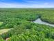 Expansive aerial perspective of the residence amidst a serene landscape of green trees and a calm lake at 657 Lakeview Dr, Stem, NC 27581