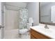 Full bathroom with a shower/tub combo, oak vanity, framed mirror, and floral shower curtain at 657 Lakeview Dr, Stem, NC 27581
