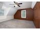 Bedroom with neutral carpet, ceiling fan, a side window and brown accent wall at 657 Lakeview Dr, Stem, NC 27581