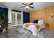 Stylish bedroom with a large window, accent wall, plush carpet, and modern decor at 657 Lakeview Dr, Stem, NC 27581