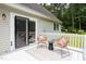Relaxing outdoor deck with woven chairs, sliding glass doors, and peaceful wooded views at 657 Lakeview Dr, Stem, NC 27581